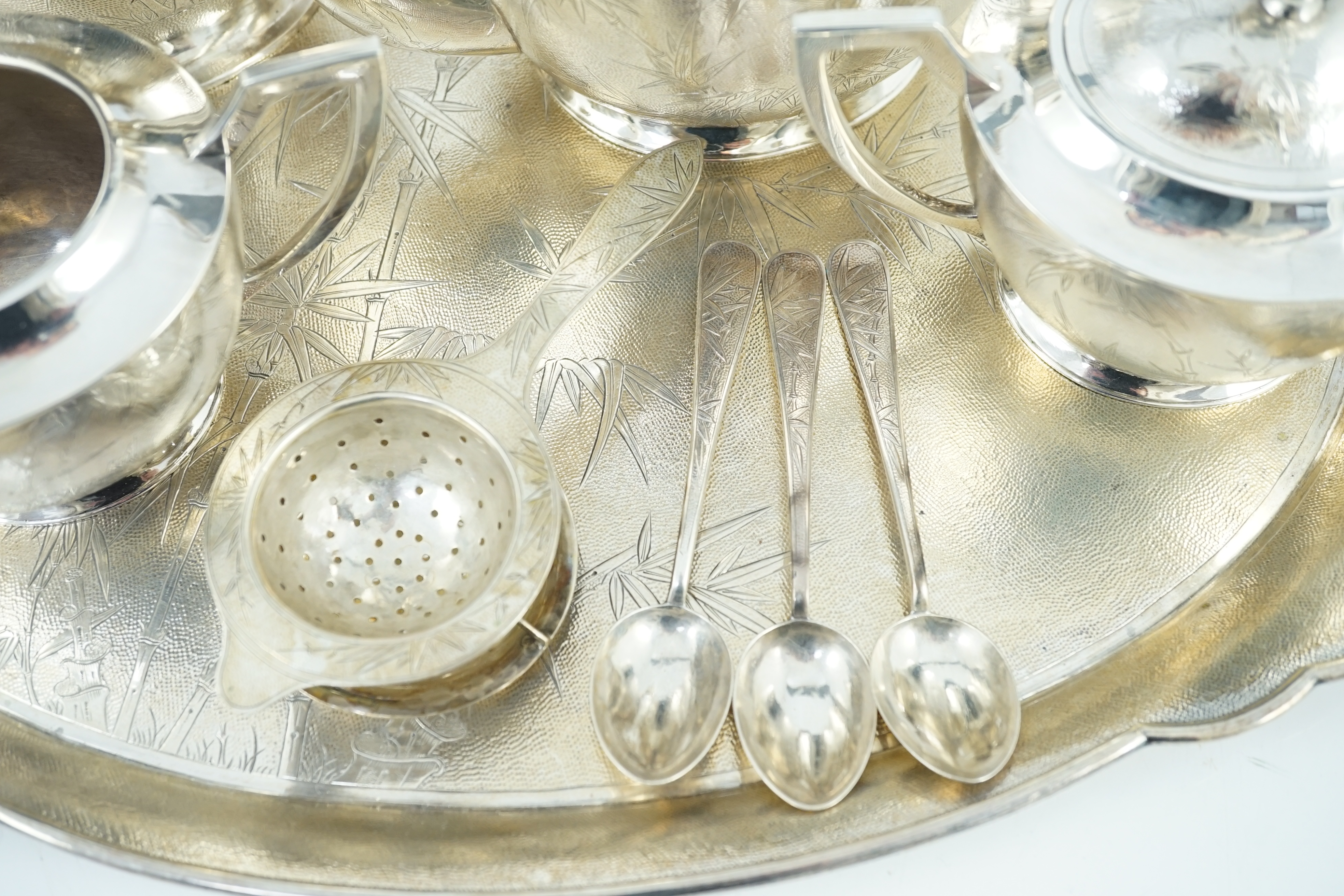 A late 19th/early 20th century Chinese Export sterling silver four piece tea and coffee service and matching oval tea tray, three teaspoons and a tea strainer, by Tack Hing, Hong Kong